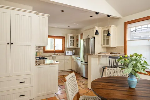 a kitchen with a refrigerator and a white cabinets