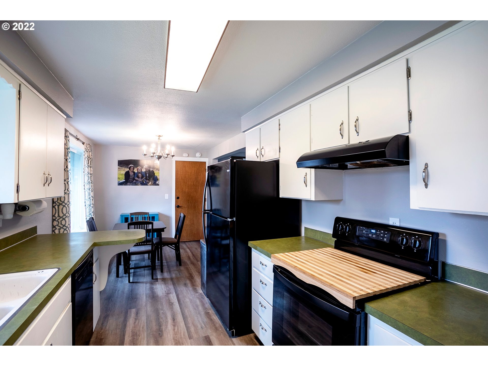 450 South 39th Place Springfield, OR 97478 - Photo 11 of 28 a kitchen with stainless steel appliances kitchen island granite countertop a refrigerator a stove a sink dishwasher and wooden cabinets with wooden floor