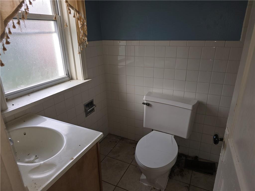 320 Main Street Fayette City, PA 15438 - Photo 9 of 28 a white toilet sitting next to a bathroom sink and a window