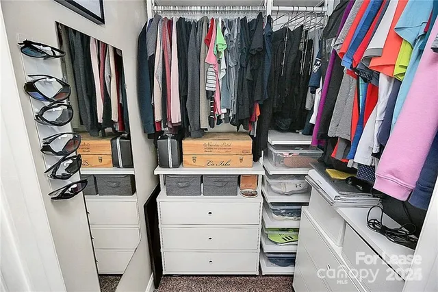 a view of walk in closet with clothes and shoes