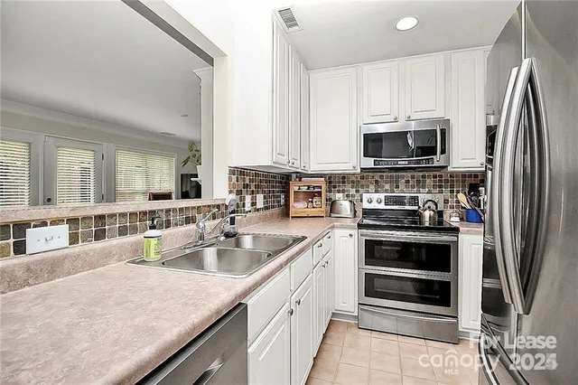 a kitchen with stainless steel appliances granite countertop a stove microwave and refrigerator