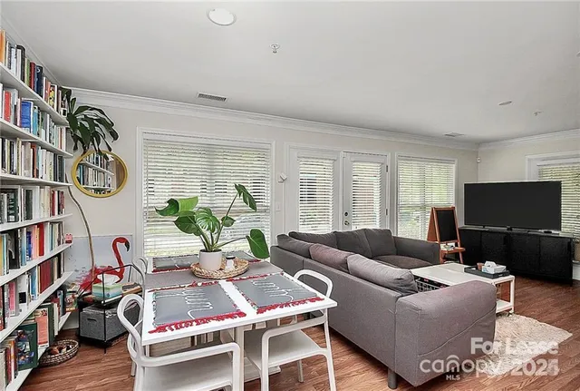 a living room with furniture a bookshelf and a flat screen tv