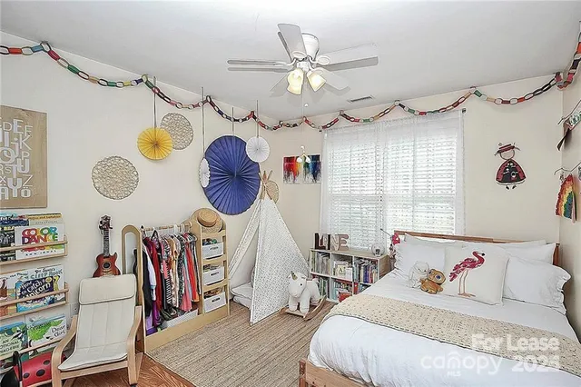a bedroom with a bed a chandelier and a window