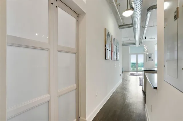 a view of a hallway with wooden floor and cabinets