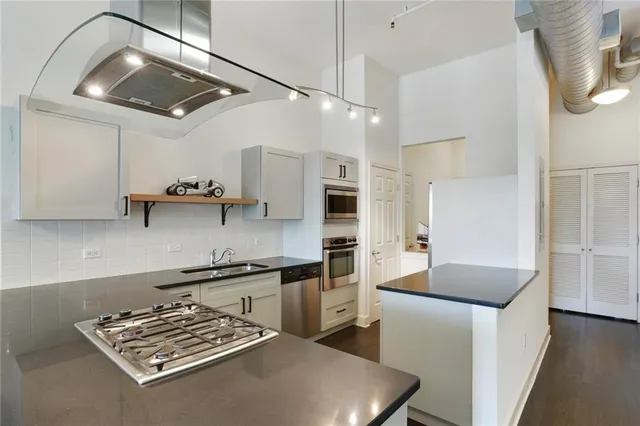 a kitchen with stainless steel appliances granite countertop a sink stove and refrigerator