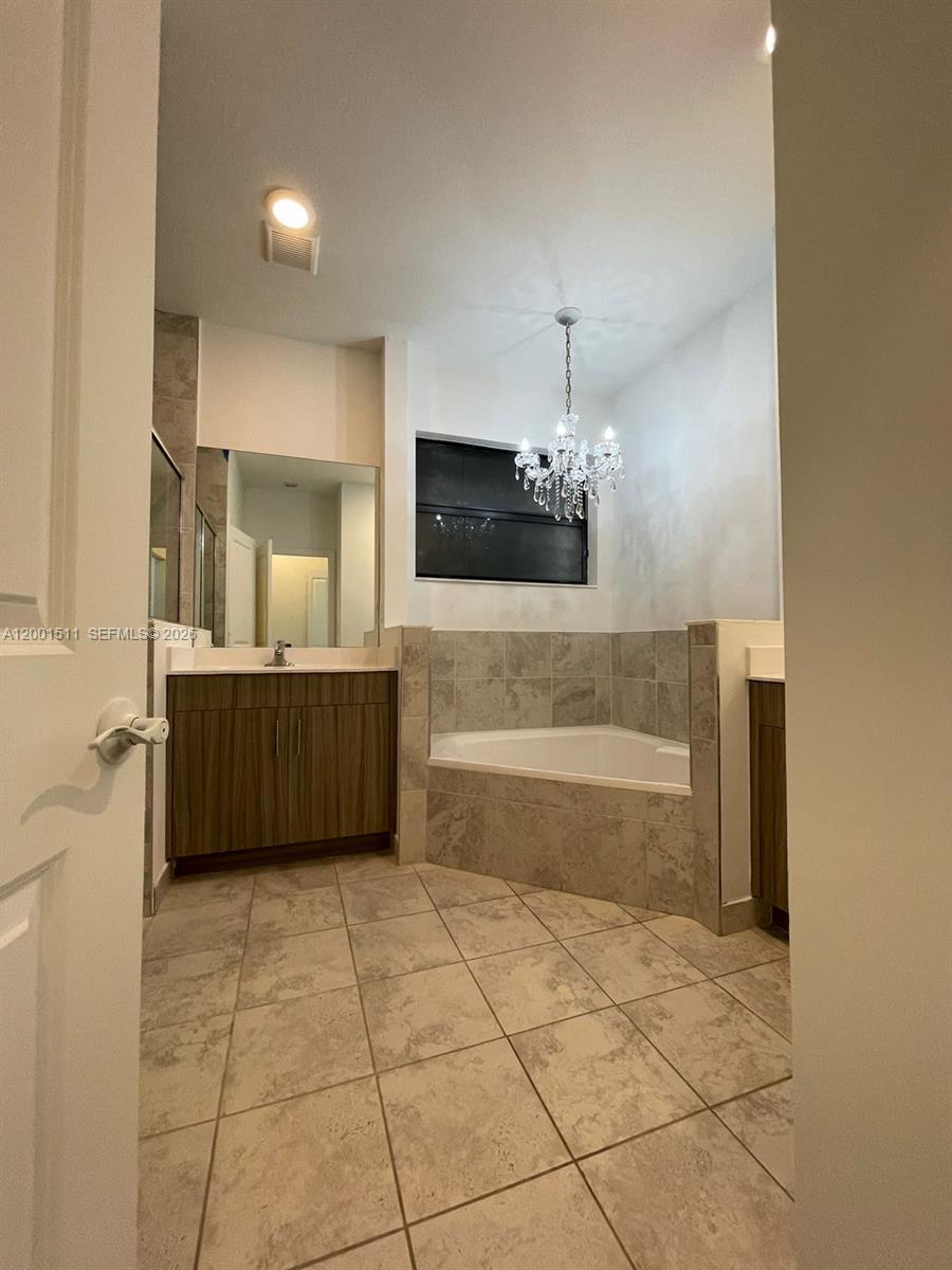 4451 Southwest 159th Path Miami, FL 33185 - Photo 11 of 24 a bathroom with a sink a mirror and bathtub