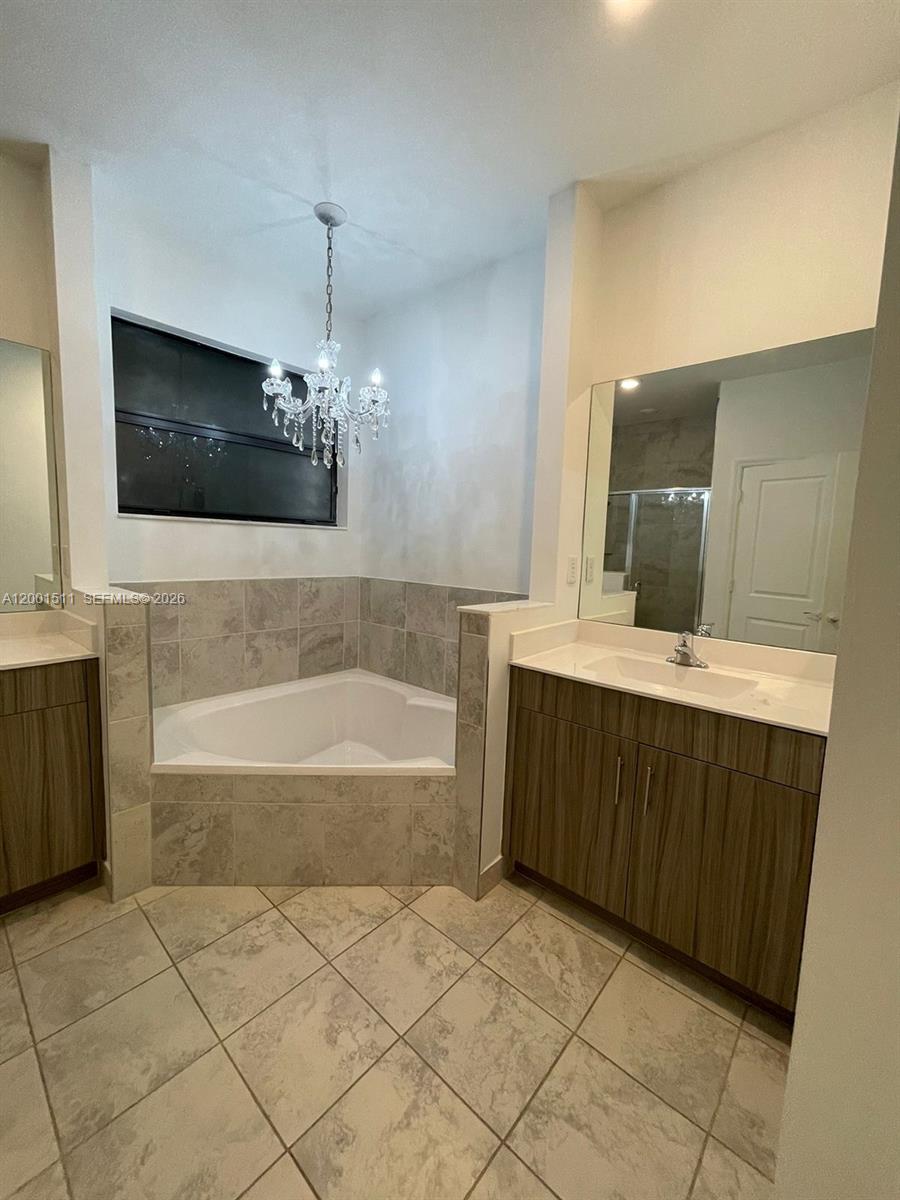 4451 Southwest 159th Path Miami, FL 33185 - Photo 12 of 24 a bathroom with a sink a large mirror and a bathtub