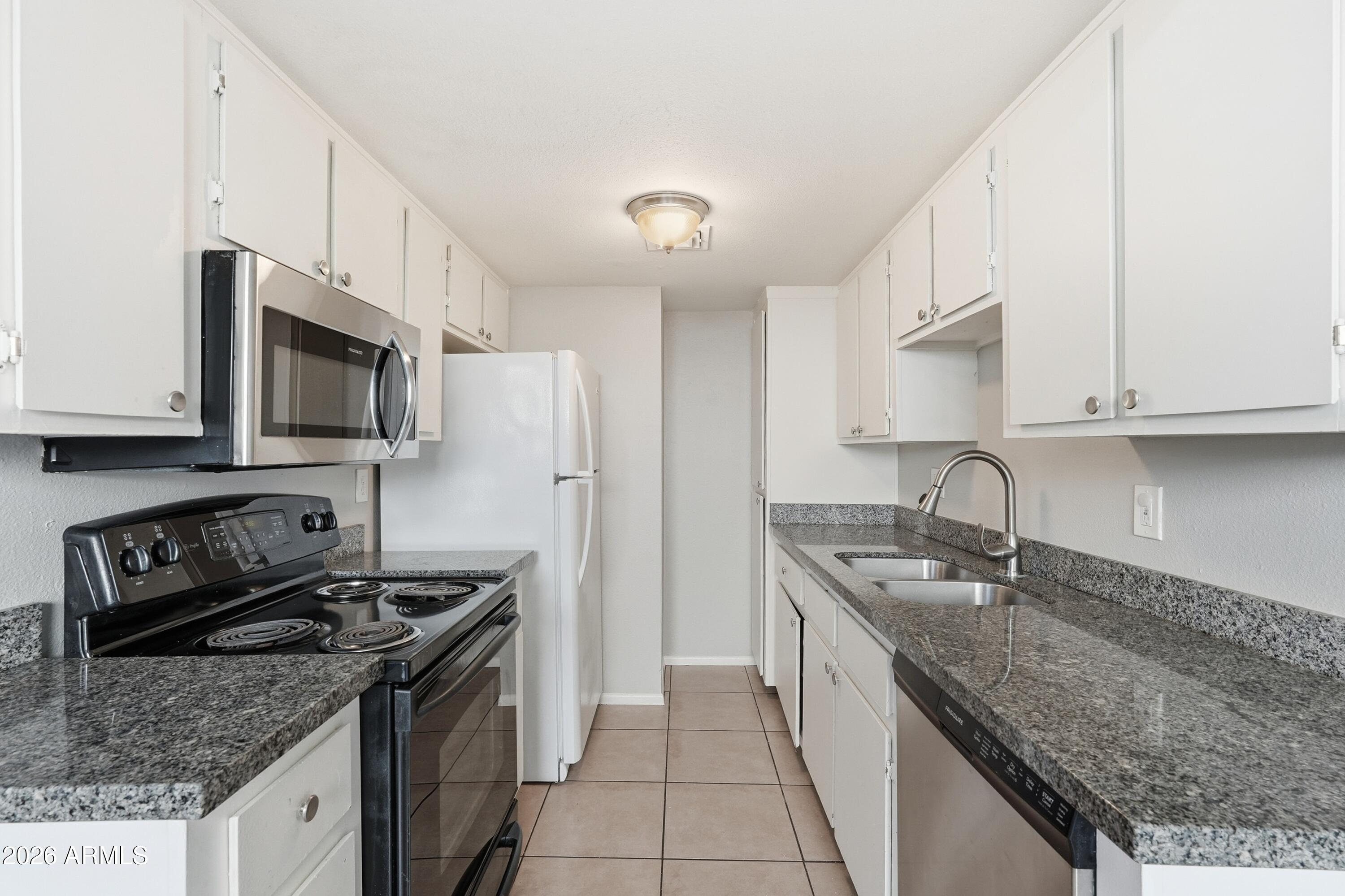 860 East Brown Road, Unit 29 Mesa, AZ 85203 - Photo 24 of 54 a kitchen with stainless steel appliances granite countertop a sink stove and refrigerator