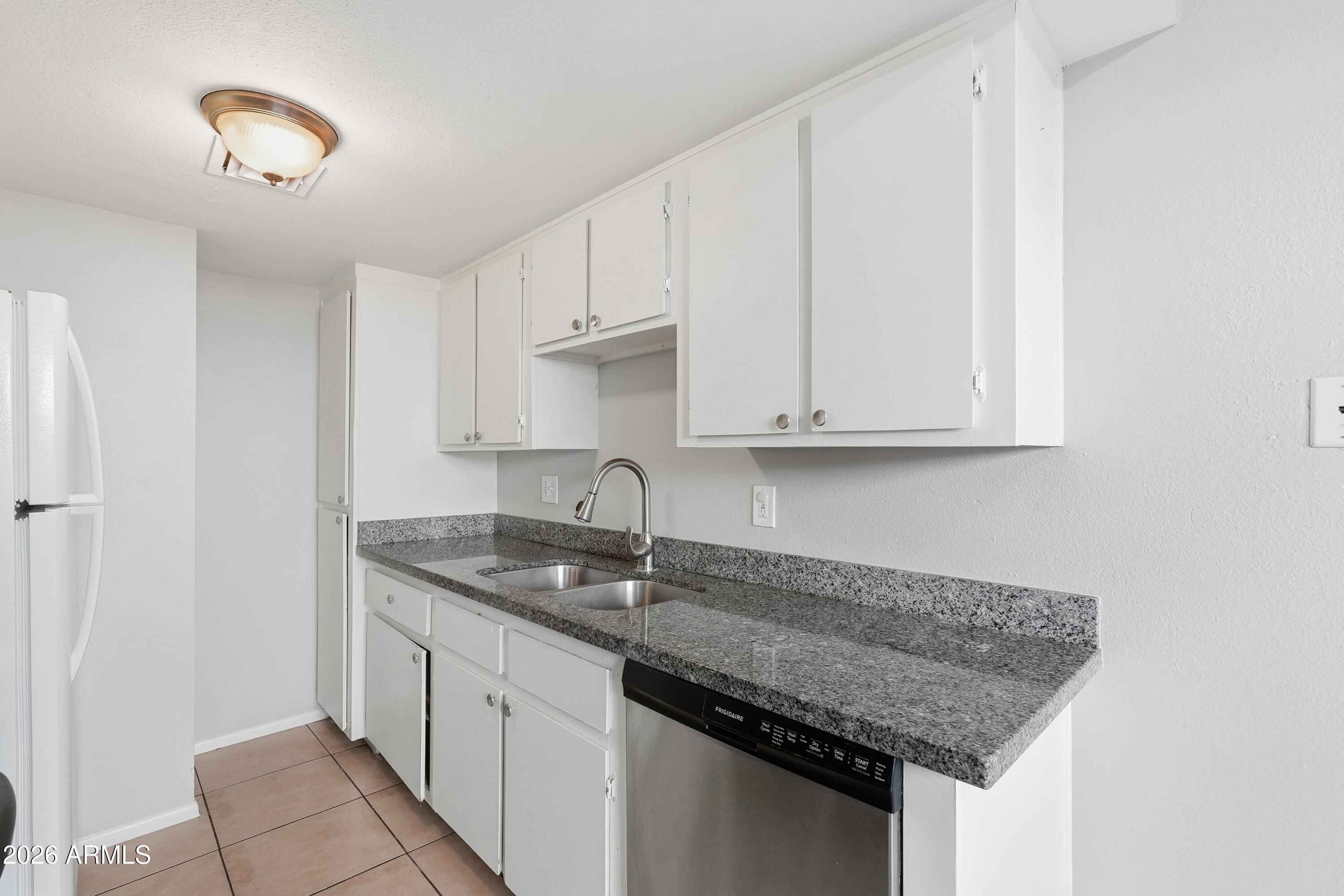 860 East Brown Road, Unit 29 Mesa, AZ 85203 - Photo 25 of 54 a kitchen with stainless steel appliances granite countertop a sink dishwasher and cabinets with wooden floor