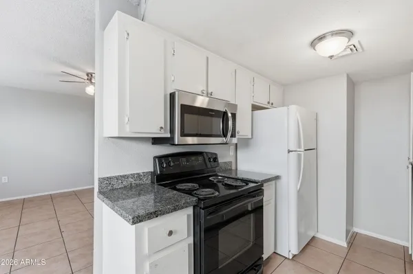 a kitchen with stainless steel appliances granite countertop a refrigerator stove and microwave