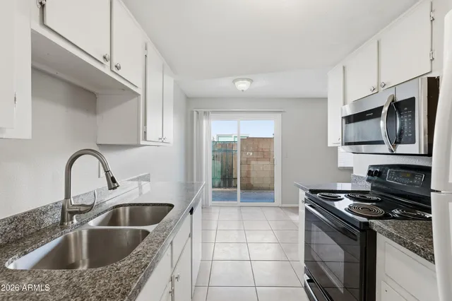 a kitchen with stainless steel appliances granite countertop a sink a stove and a refrigerator