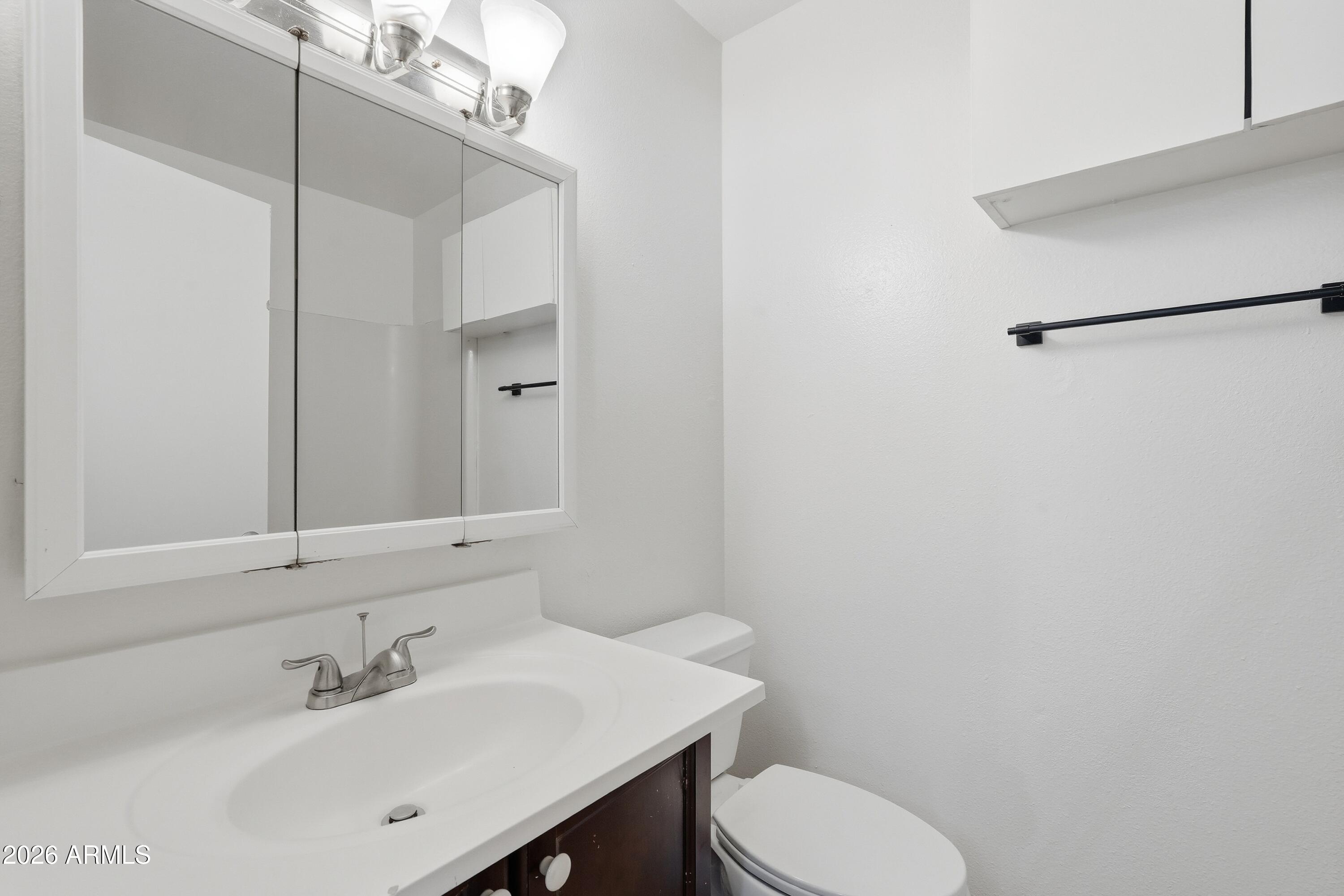 860 East Brown Road, Unit 29 Mesa, AZ 85203 - Photo 36 of 54 a bathroom with a sink a toilet and mirror