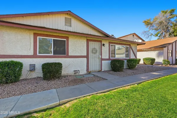 a front view of a house with a yard and potted plants