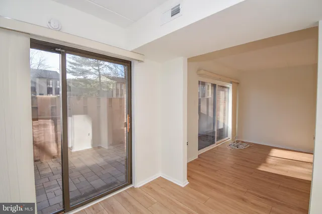 a view of hallway with a large window and wooden floor