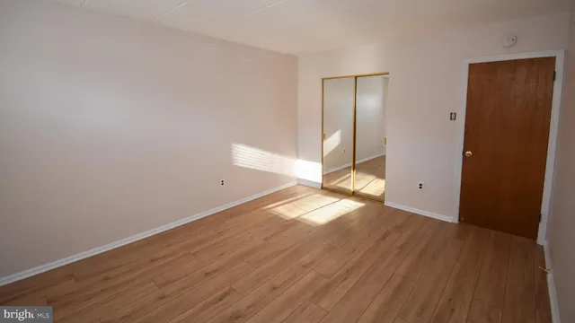a view of empty room with wooden floor
