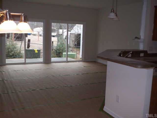 7244 Racine Way Raleigh, NC 27615 - Photo 2 of 5 family room view from entry foyer/kitchen area. Hardwoods are covered with protective paper. Other