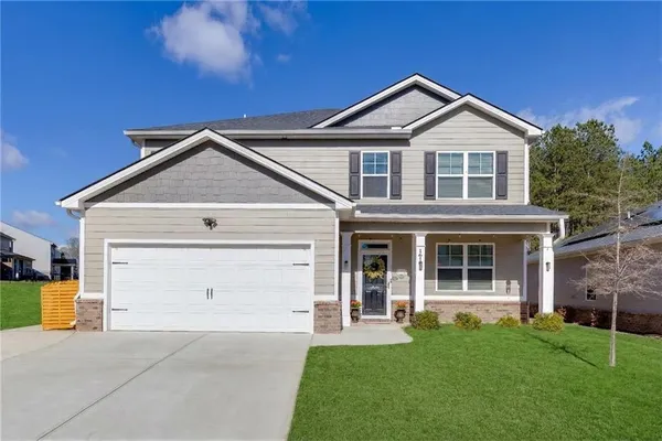 a front view of a house with a yard and garage