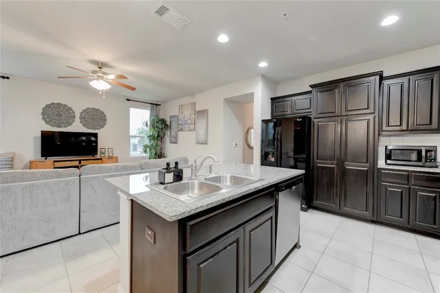 a kitchen with kitchen island granite countertop a sink appliances and cabinets