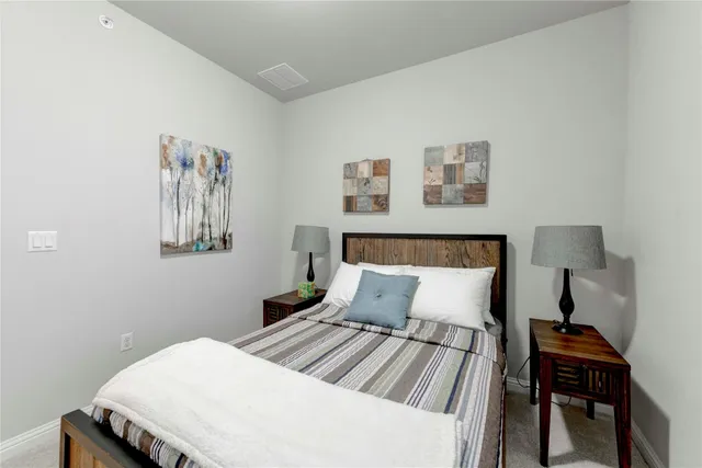 a bedroom with a bed and a lamp on table