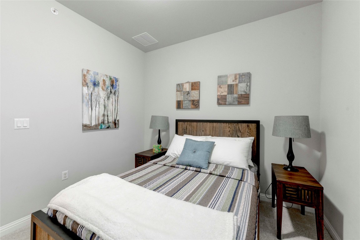 13800 Lyndhurst Street, Unit 125 Austin, TX 78717 - Photo 17 of 27 a bedroom with a bed and a lamp on table