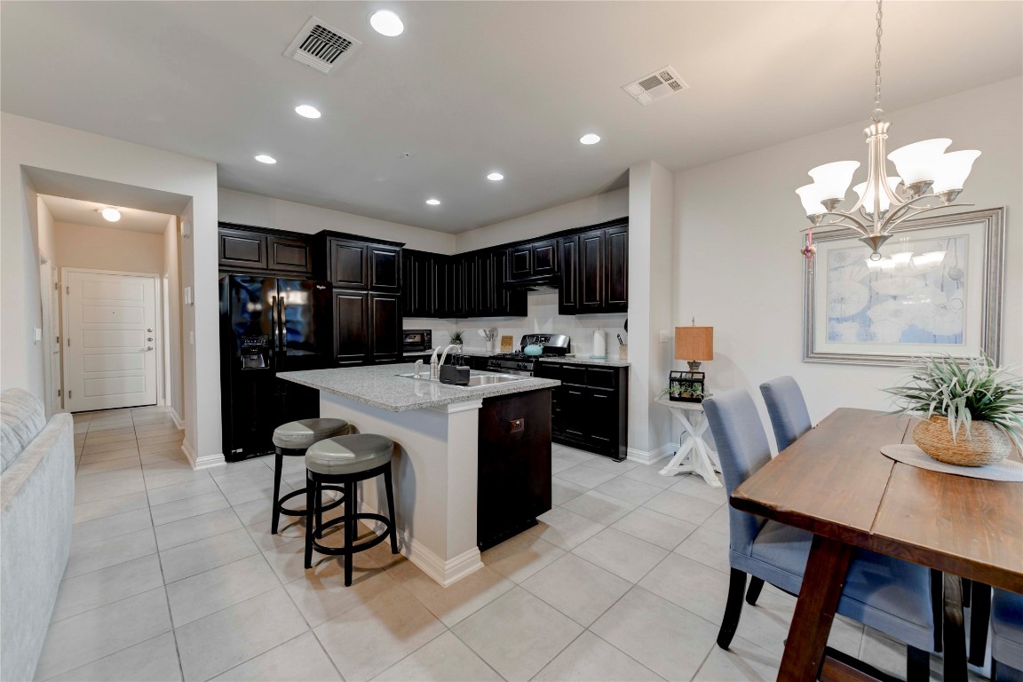13800 Lyndhurst Street, Unit 125 Austin, TX 78717 - Photo 18 of 27 a kitchen with a dining table chairs and refrigerator