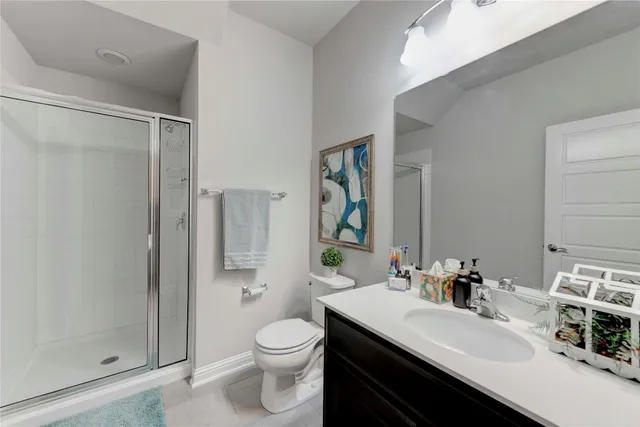 a bathroom with a sink toilet vanity and shower