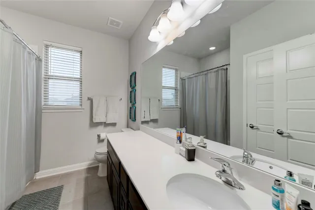 a bathroom with double vanity and a mirror