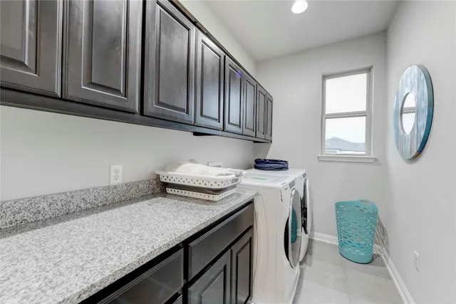 a utility room with granite countertop a sink a washer and dryer