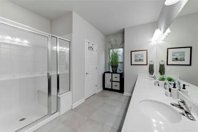 a spacious bathroom with a tub shower and mirror