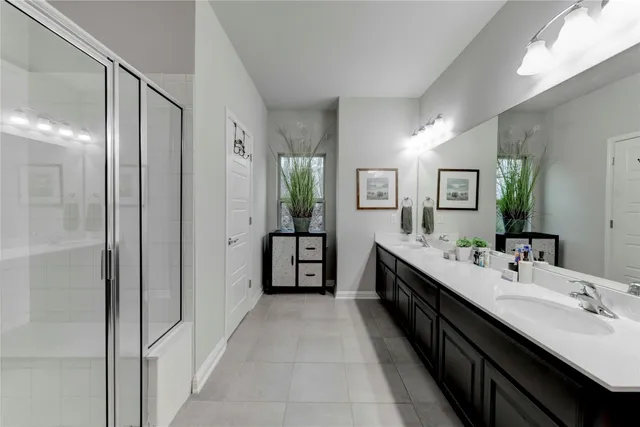 a bathroom with a double vanity sink and mirror with shower
