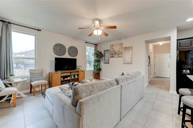 a living room with furniture a flat screen tv and a large window