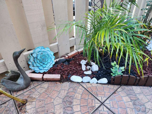 a view of a backyard with chairs and potted plants