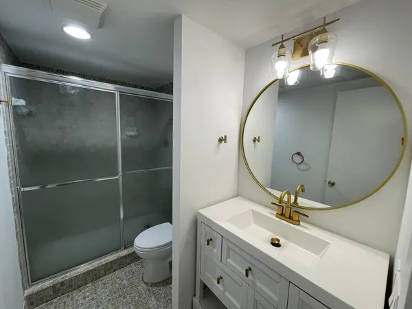 a bathroom with a toilet a sink and mirror