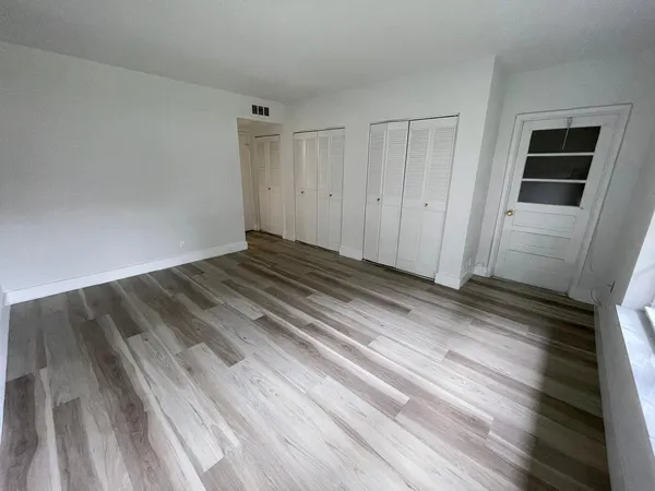 a view of empty room with wooden floor and entryway