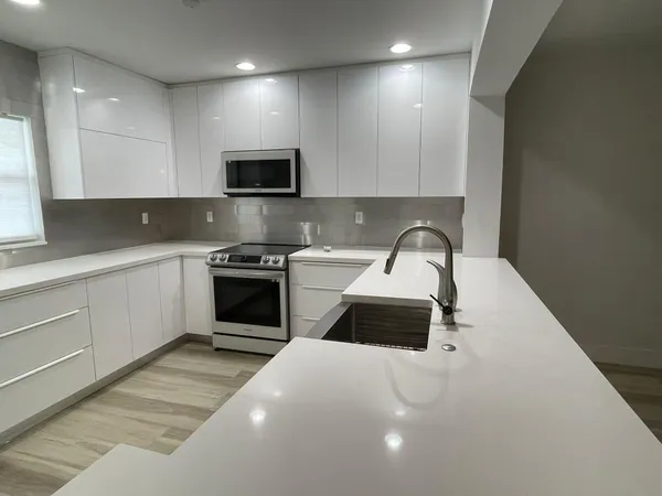 a kitchen with a sink a microwave and cabinets