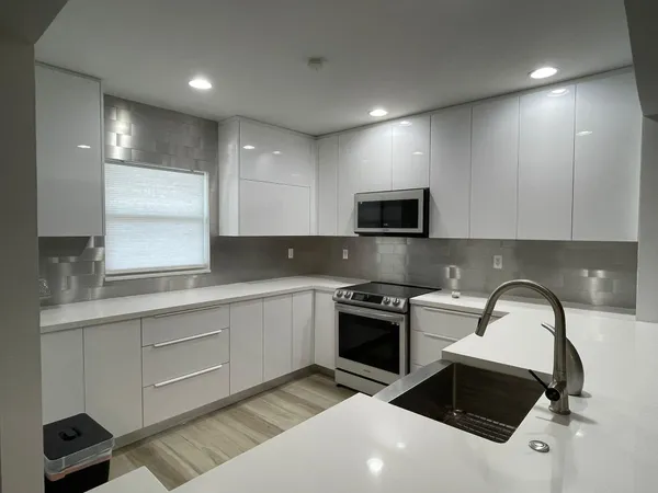 a kitchen with a sink stainless steel appliances and cabinets