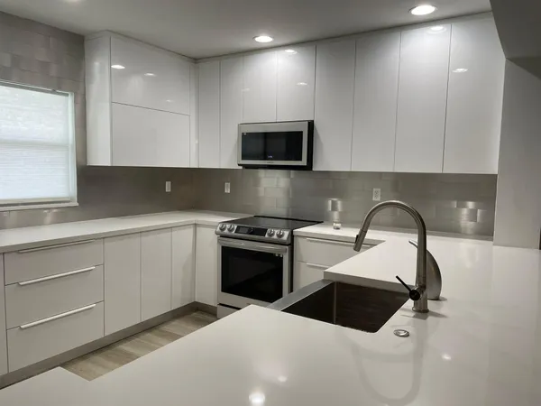 a kitchen with a sink a stove and cabinets