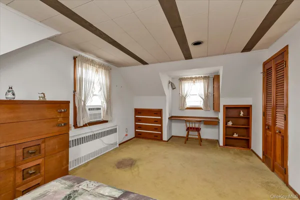 a view of a bedroom with furniture and windows