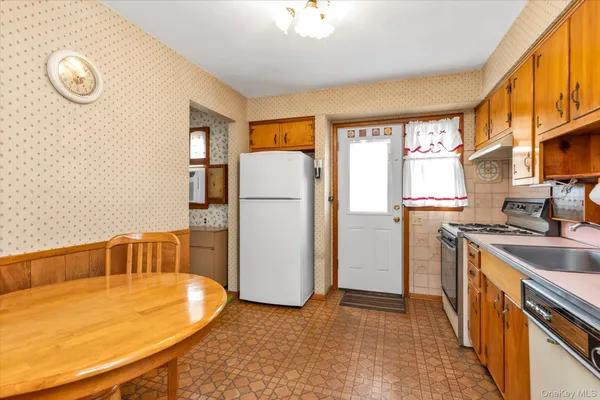 a kitchen with a refrigerator a stove and a window