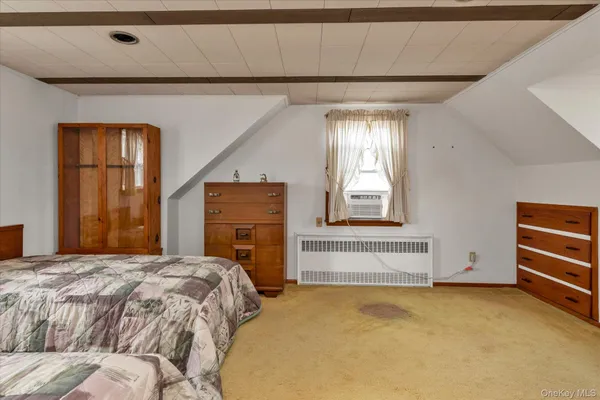 a bedroom with a bed dresser and a window