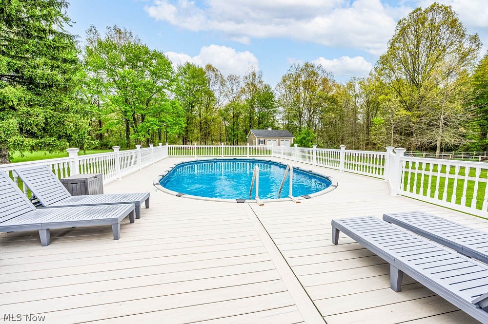 6787 South Palmyra Road Canfield, OH 44406 - Photo 25 of 30 Outdoor deck featuring an oval swimming pool with integrated steps
