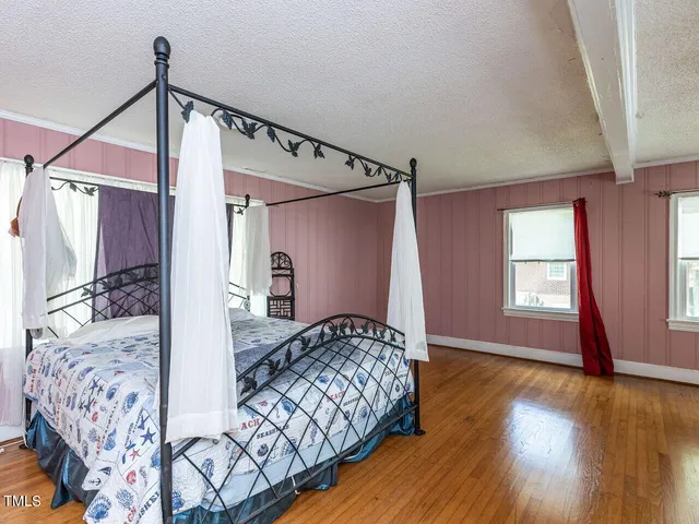 a bedroom with a bed and wooden floor
