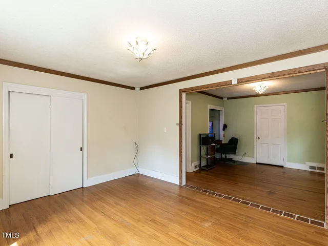 a room with a bed and a view of living room
