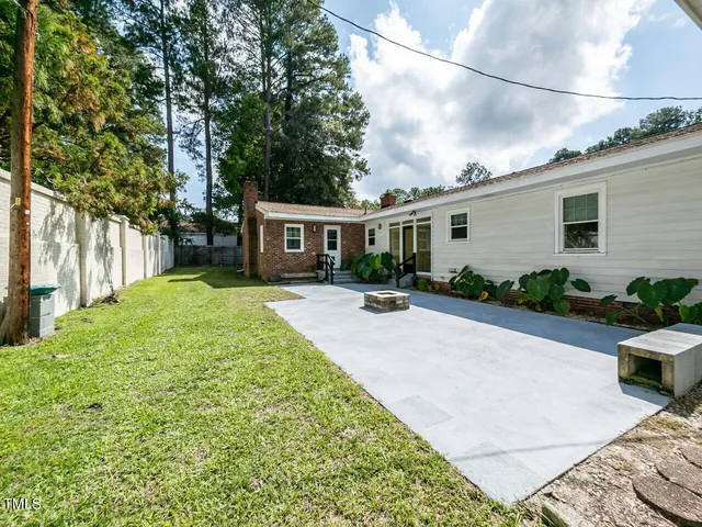 a view of a house with backyard and sitting area