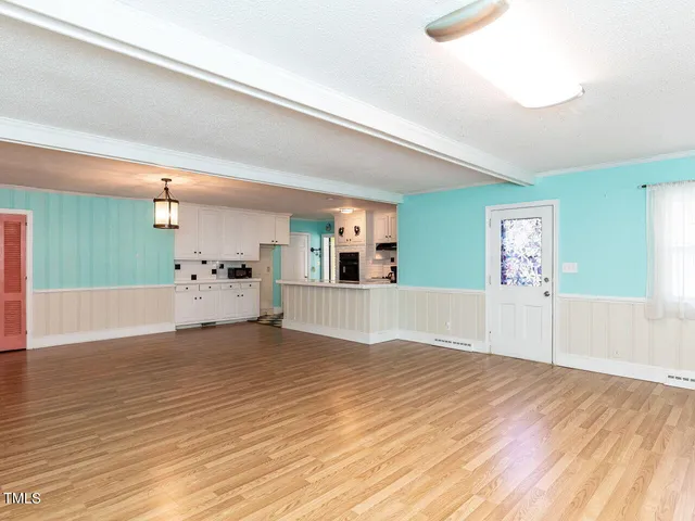 a view of empty room with wooden floor and fireplace