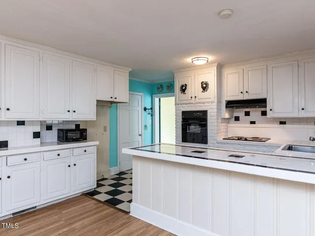a kitchen with granite countertop a sink stove and cabinets