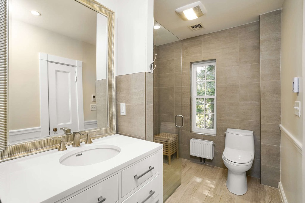 173 School Street Milton, MA 02186 - Photo 21 of 30 a bathroom with a toilet sink and mirror