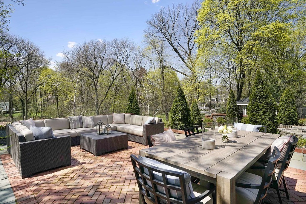 173 School Street Milton, MA 02186 - Photo 27 of 30 a view of a patio with couches and a table and chairs with wooden floor and fence