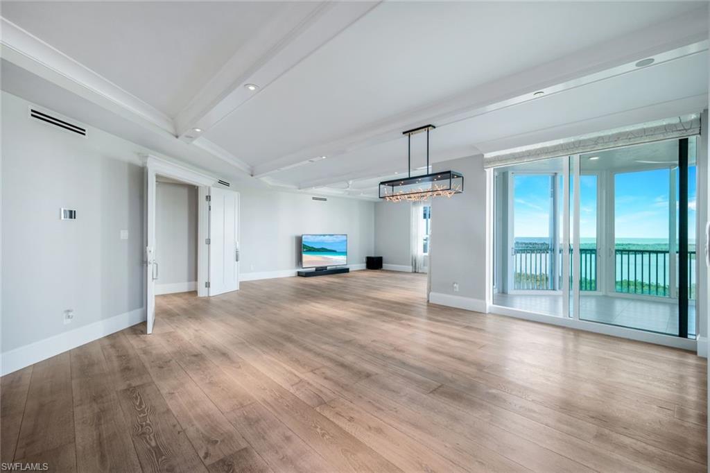 285 Grande Way, Unit 1006 Naples, FL 34110 - Photo 21 of 46 a view of a livingroom with wooden floor a ceiling fan and window