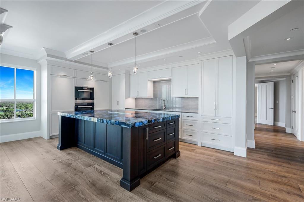 285 Grande Way, Unit 1006 Naples, FL 34110 - Photo 24 of 46 a kitchen with stainless steel appliances kitchen island wooden cabinets and granite counter tops
